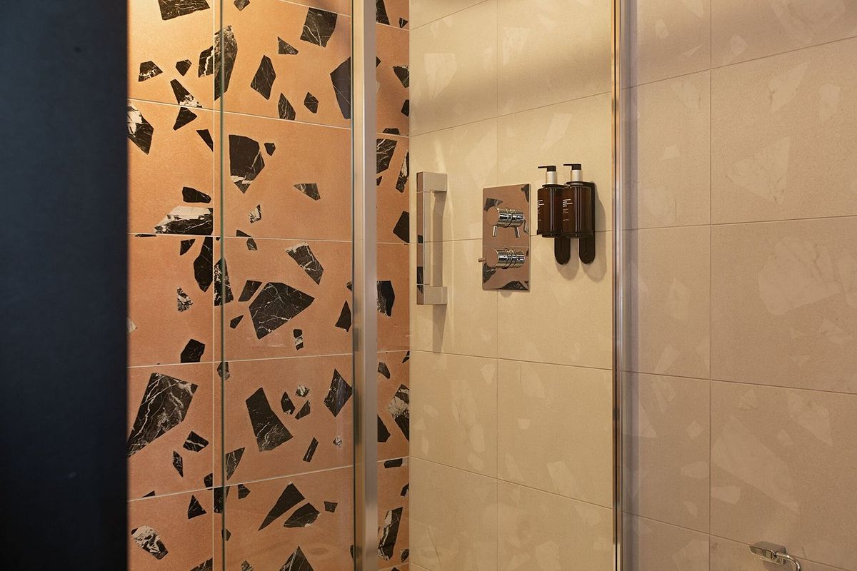 Modern bathroom at The Address Wren Glasgow with a walk-in shower, terrazzo-style finishes and contemporary details.