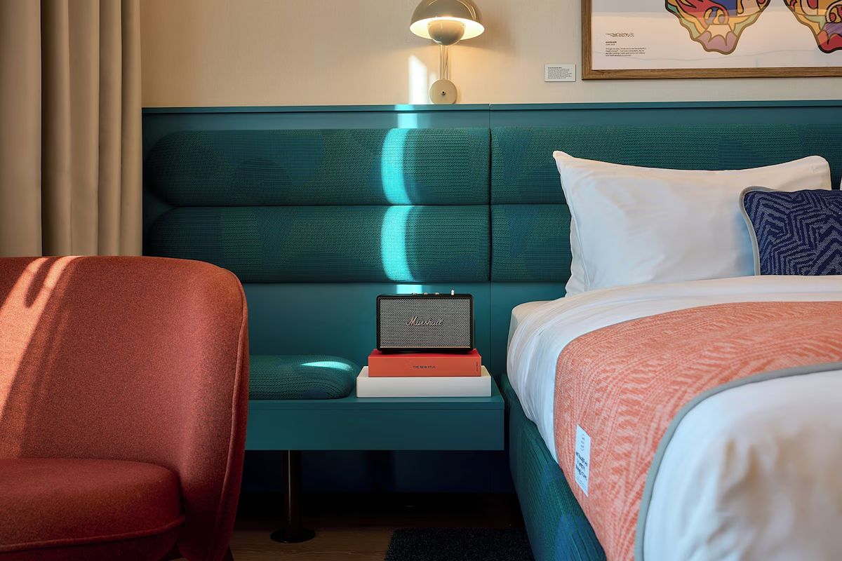 Bedroom detail at The Social Hub Glasgow with teal upholstery, coral accents and a modern, design-led feel.