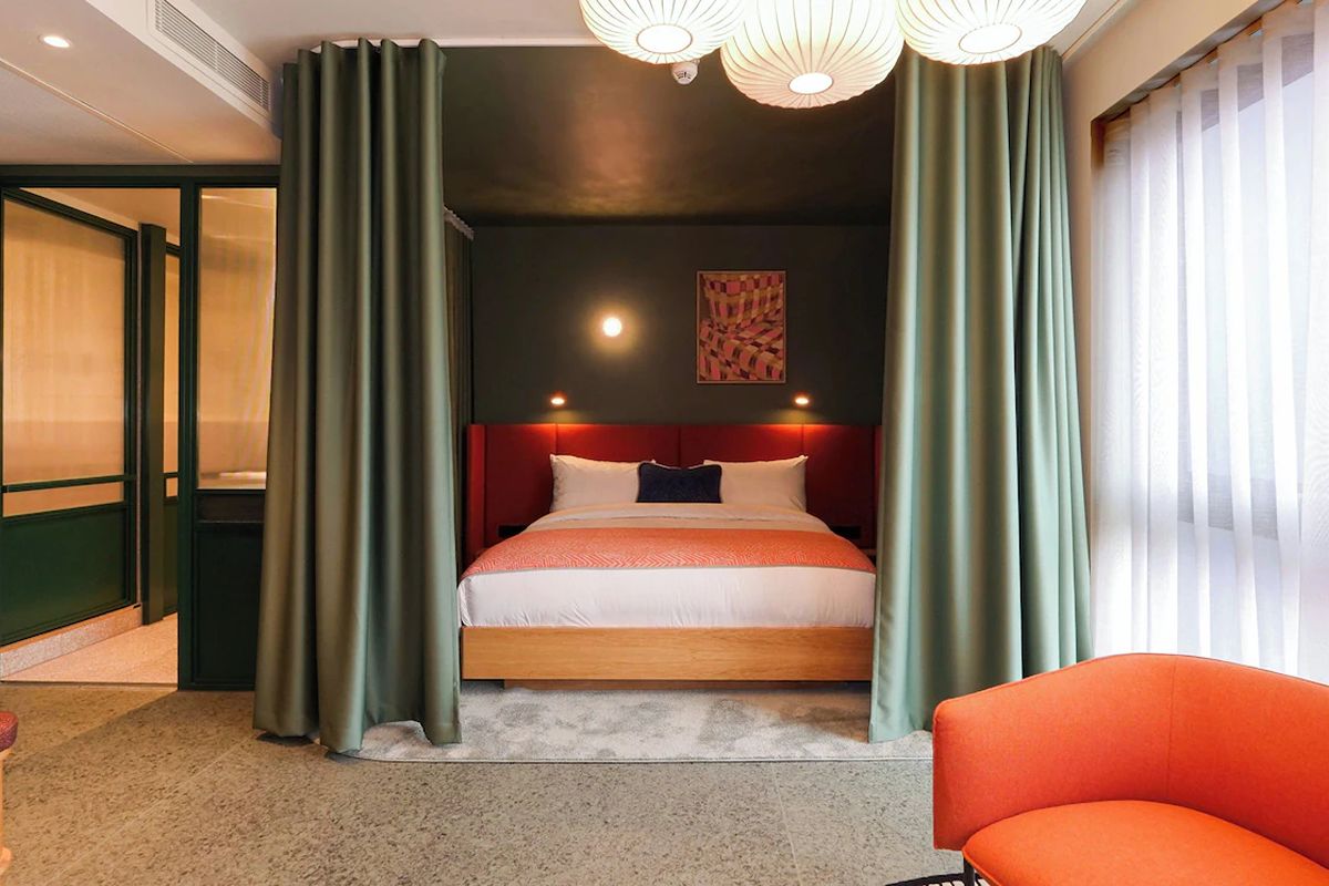 Stylish bedroom at The Social Hub Glasgow with statement lighting, soft draped partitions and a contemporary layout.