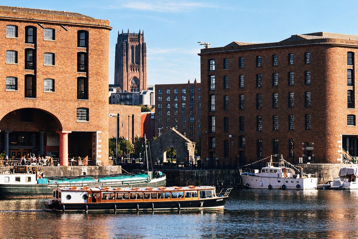 Liverpool hen weekend boat cruising through the Royal Albert Dock with Liverpool Cathedral in the background.