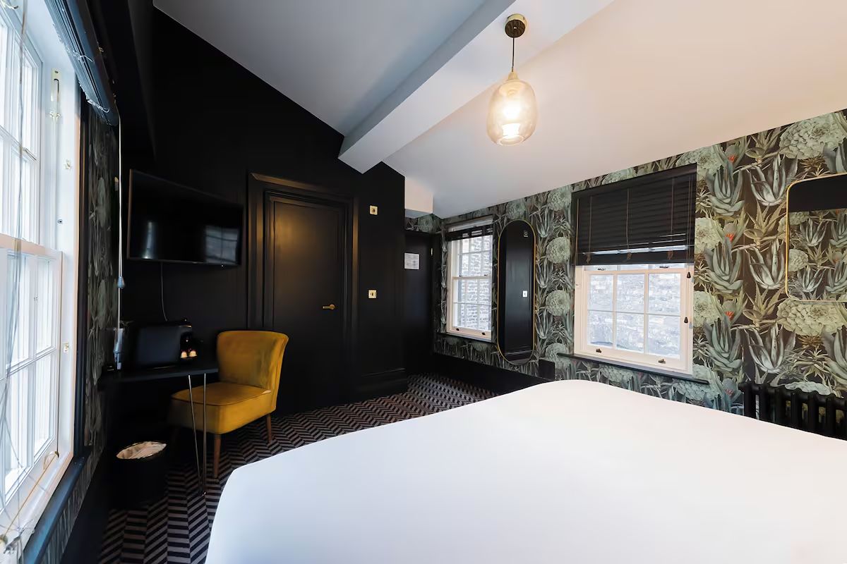 Characterful bedroom at 19 Duke Street Liverpool with botanical wallpaper.