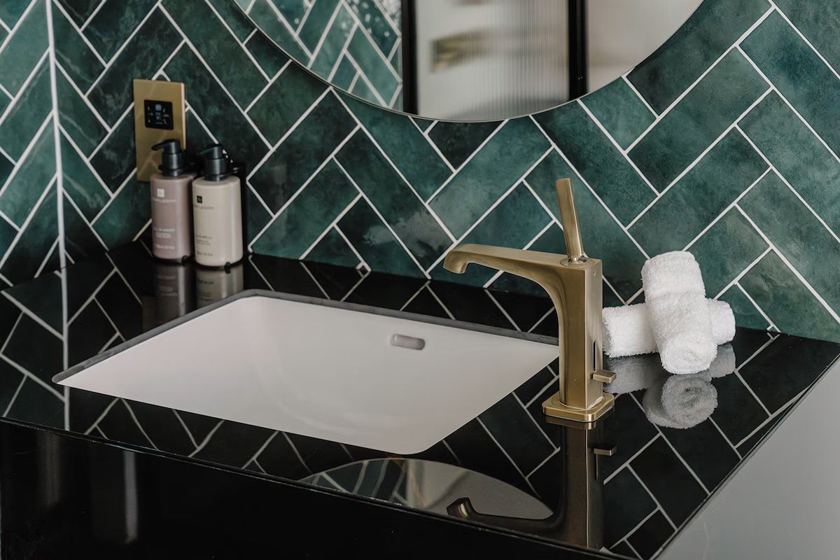 Modern bathroom at The Halyard Liverpool with green herringbone tiles.