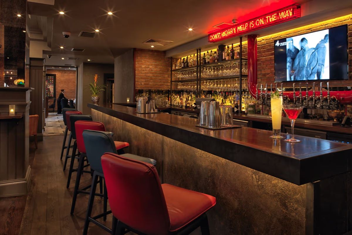 Malmaison Newcastle bar with moody lighting and red stools on the Quayside
