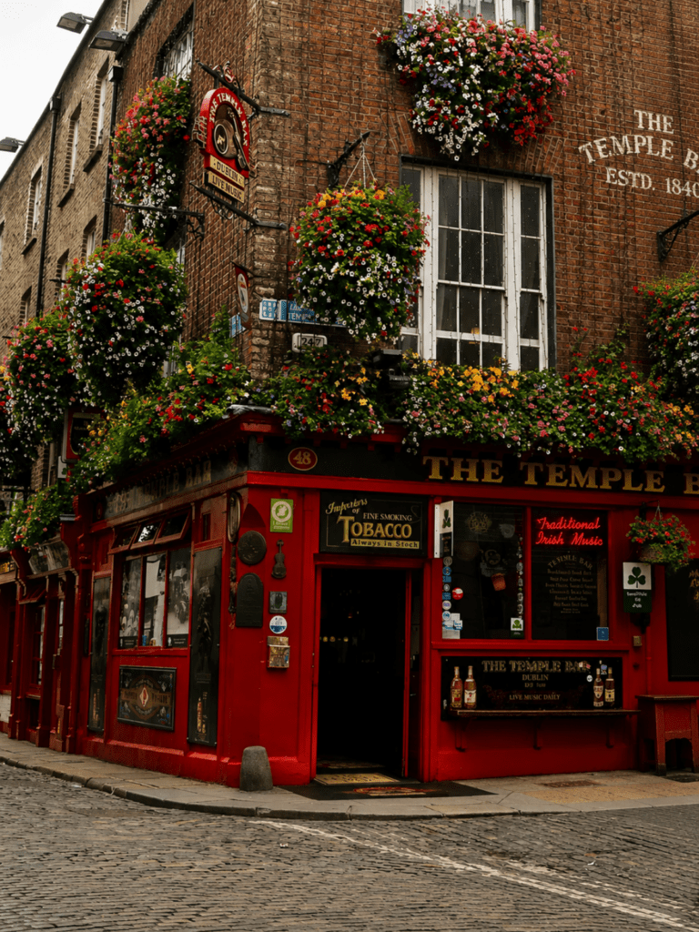 The red-fronted Temple Bar pub in Dublin covered in hanging flower baskets, a classic first stop for Dublin hen do activities.